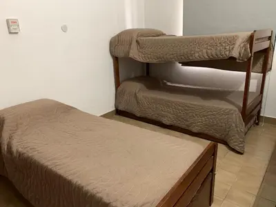 a room with two bunk beds and a bench at La Morada de sus Sueños II in San Roque