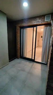 a room with a large glass door with a balcony at Habitana Firpo Cofico con cochera in Cordoba