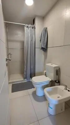 a bathroom with a toilet and a shower and a sink at Habitana Firpo Cofico con cochera in Cordoba