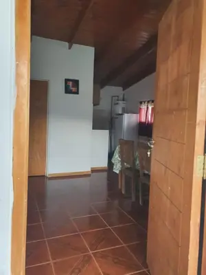 a room with a kitchen with a table and a refrigerator at Cabañas Sierra Maestra in Bialet Massé