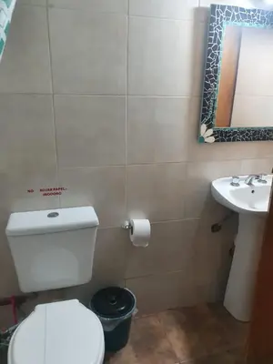 a bathroom with a toilet and a sink at Cabañas Sierra Maestra in Bialet Massé