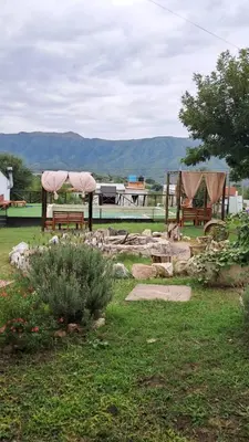 a park with benches and tables in the grass at Cabañas Sierra Maestra in Bialet Massé