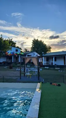 a view of a house and a pool of water at Cabañas Sierra Maestra in Bialet Massé