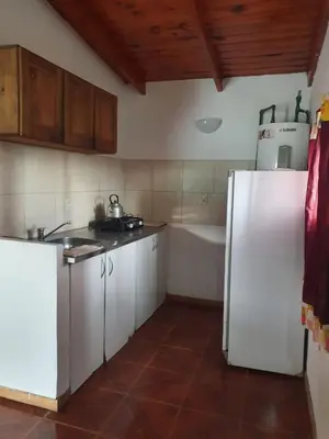 a kitchen with a refrigerator and a sink and a tub at Cabañas Sierra Maestra in Bialet Massé