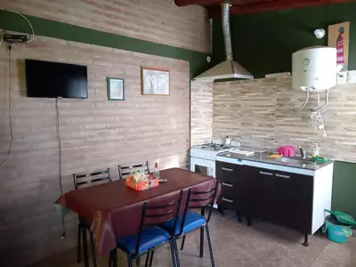 a kitchen with a table and a sink and a stove at Cabañas doña chiche in San Lorenzo