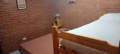 a small bedroom with a bed and a small night stand at Cabañas doña chiche in San Lorenzo