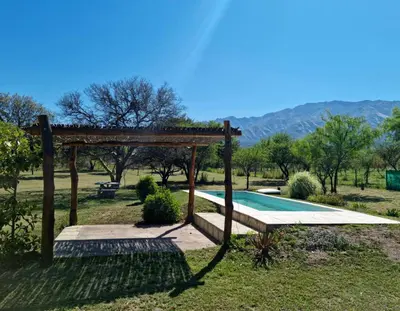 a swimming pool with a wooden pergola next to a field at Finca La Hermosa in San Javier