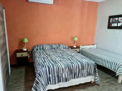two beds in a room with orange walls at Finca La Hermosa in San Javier