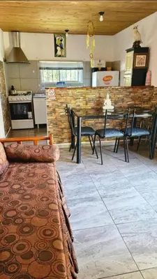 a living room with a table and chairs and a kitchen at La Bonita, casa en alquiler frente al lago in La Estancia