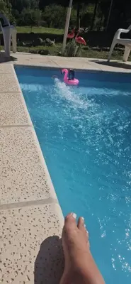 a person laying on the edge of a swimming pool at La Bonita, casa en alquiler frente al lago in La Estancia