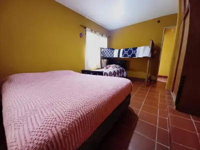 a bedroom with two beds and a yellow wall at Abrazo del Sol in Villa Santa Cruz del Lago