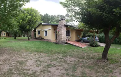 a house with a car parked in front of it at La Olla Complejo Turistico in Santa Rosa de Calamuchita