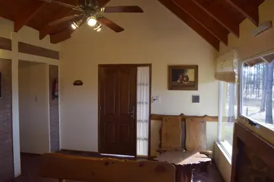 a living room with a ceiling fan and a door at La Olla Complejo Turistico in Santa Rosa de Calamuchita