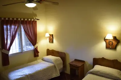 a bedroom with two beds and a window at La Olla Complejo Turistico in Santa Rosa de Calamuchita