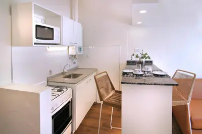 a small kitchen with a sink and a stove top oven at La Olla Complejo Turistico in Santa Rosa de Calamuchita