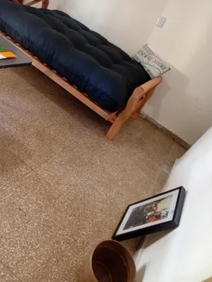 a bed sitting in a room next to a table at Alquimia Dos in Cordoba