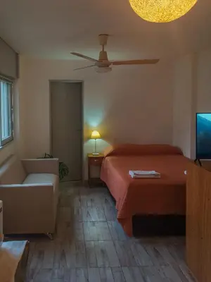 a bedroom with a bed and a couch and a tv at Monoambiente Céntrico - Alberdi, Córdoba Capital - Cerca del Centro, Hospital Nacional de Clínicas, Plaza de la Música, Nuevocentro Shopping y Hotel Quinto Centenario in Cordoba