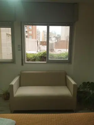a couch sitting in a room with two windows at Monoambiente Céntrico - Alberdi, Córdoba Capital - Cerca del Centro, Hospital Nacional de Clínicas, Plaza de la Música, Nuevocentro Shopping y Hotel Quinto Centenario in Cordoba