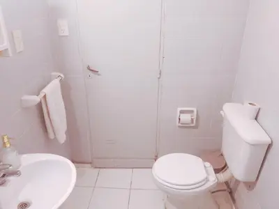 a white bathroom with a toilet and a sink at Monoambiente Céntrico - Alberdi, Córdoba Capital - Cerca del Centro, Hospital Nacional de Clínicas, Plaza de la Música, Nuevocentro Shopping y Hotel Quinto Centenario in Cordoba