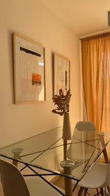 a glass table with two chairs and a vase with flowers at Urban 362 in Cordoba