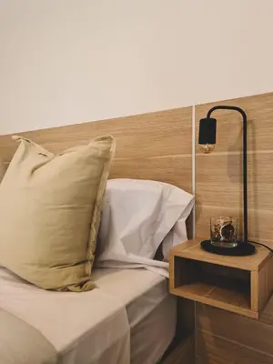 a bed with a pillow and a table with a lamp at Urban 362 in Cordoba