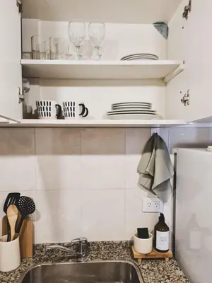 a kitchen counter with plates and glasses on shelves at Urban 362 in Cordoba