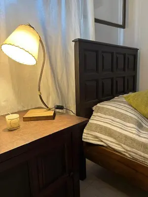 a lamp sitting on a table next to a bed at Posada Don Ramón in Estancia Vieja