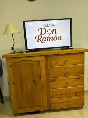 a television on top of a wooden dresser at Posada Don Ramón in Estancia Vieja