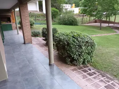 a pole on a sidewalk next to a bush at Posada Don Ramón in Estancia Vieja
