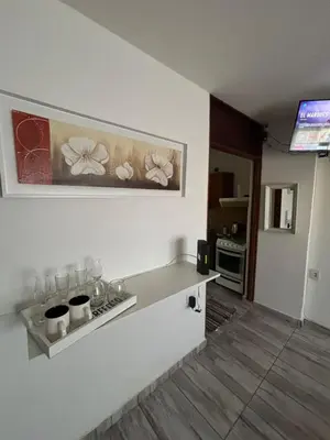 a kitchen with a counter and a tv in a room at Depto en pleno centro Villa Carlos Paz in Villa Carlos Paz
