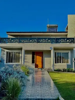 a house with a red door and a driveway at Jacarandá in Villa Carlos Paz