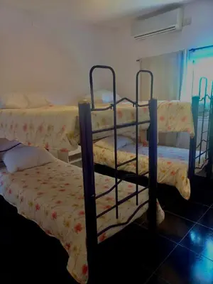a room with two bunk beds in a room at Jacarandá in Villa Carlos Paz