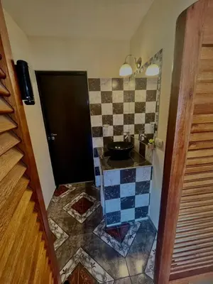 a bathroom with a sink and a tiled floor at Jacarandá in Villa Carlos Paz