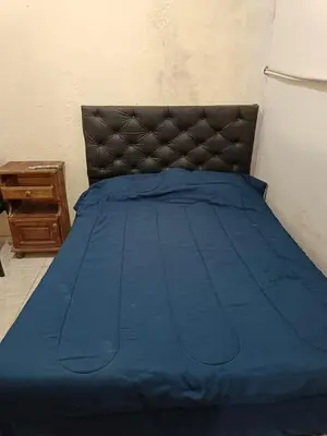 a bed with a blue comforter on top of it at Cabrales in Cordoba