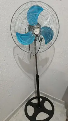 a blue fan sitting on a pole with a black base at Cabrales in Cordoba