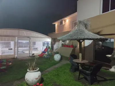 a patio with a table and a straw umbrella at Brisas del sol in Villa Carlos Paz