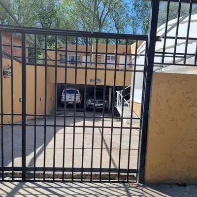 a building with a car parked in a parking lot at Brisas del sol in Villa Carlos Paz