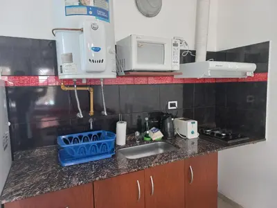 a kitchen counter with a sink and a microwave at Brisas del sol in Villa Carlos Paz