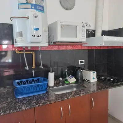 a kitchen counter with a sink and a microwave at Brisas del sol in Villa Carlos Paz
