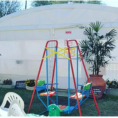 a playground with chairs and a swing set in a yard at Brisas del sol in Villa Carlos Paz