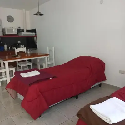 a living room with a red bed and a table at Brisas del sol in Villa Carlos Paz