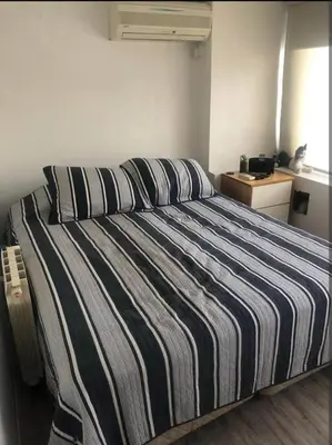 a bedroom with a striped bed with pillows on it at Dto lujoso in Cordoba