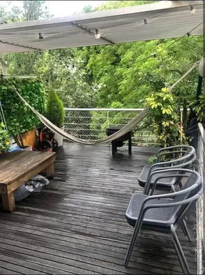 a porch with a hammock and benches on a deck at Dto lujoso in Cordoba