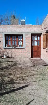 a brick house with a wooden door and windows at El rancho de cristina y victor in Arroyo de Los Patos