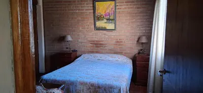a bedroom with a bed and a brick wall at El rancho de cristina y victor in Arroyo de Los Patos