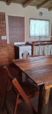 a kitchen with a wooden table and a stove at El rancho de cristina y victor in Arroyo de Los Patos