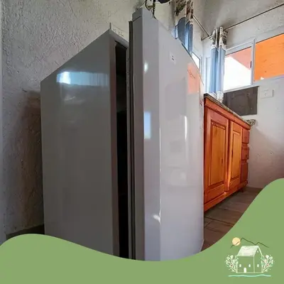 a stainless steel refrigerator in a room with a kitchen at Cabaña Don Americo in Villa García