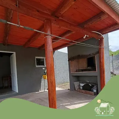 a patio with a wooden roof with a fireplace at Cabaña Don Americo in Villa García