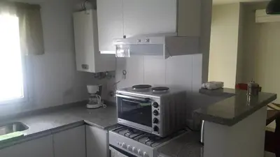 a kitchen with a stove top oven next to a sink at Apartment Nueva Córdoba in Cordoba