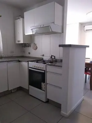 a kitchen with white cabinets and a stove top oven at Apartment Nueva Córdoba in Cordoba
